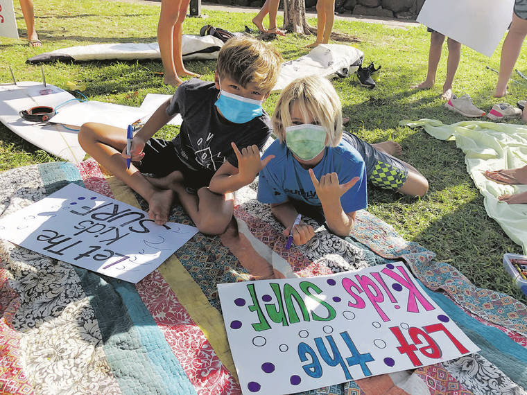 CHRISTIE WILSON / CWILSON@STARADVERTISER.COM
                                Maui “groms” Chase Lee, 10, left, and Seth Jucker, 10, finished their signs Tuesday for a rally at Lahaina Harbor to urge leaders to allow surfing competitions to resume.