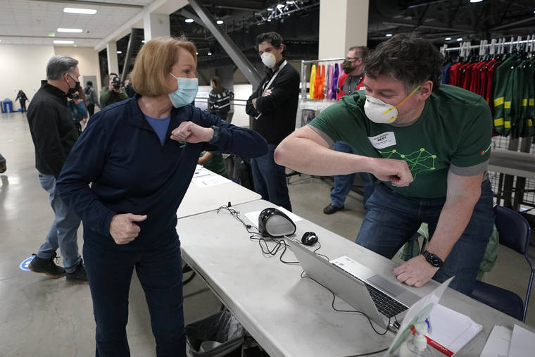 ASSOCIATED PRESS
                                Seattle Mayor Jenny Durkan, left, greeted a worker, March 13, at a volunteer check-in station, on the first day of operations at a mass COVID-19 vaccination site at the Lumen Field Events Center in Seattle, which adjoins the field where the Seattle Seahawks and the MLS soccer Seattle Sounders play their games.