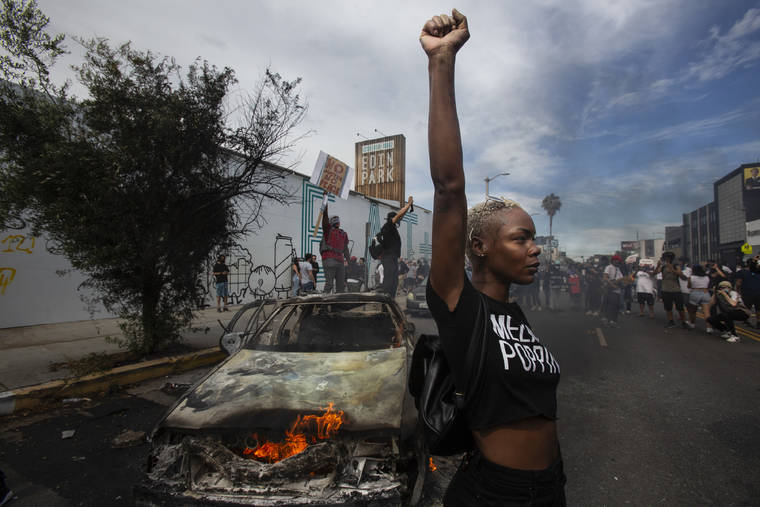 ASSOCIATED PRESS
                                A protester raised her fist in the air next to a burning police vehicle in Los Angeles, May 30, 2020, during a demonstration over the death of George Floyd. The image was part of a series of photographs by The Associated Press that won the 2021 Pulitzer Prize for breaking news photography.