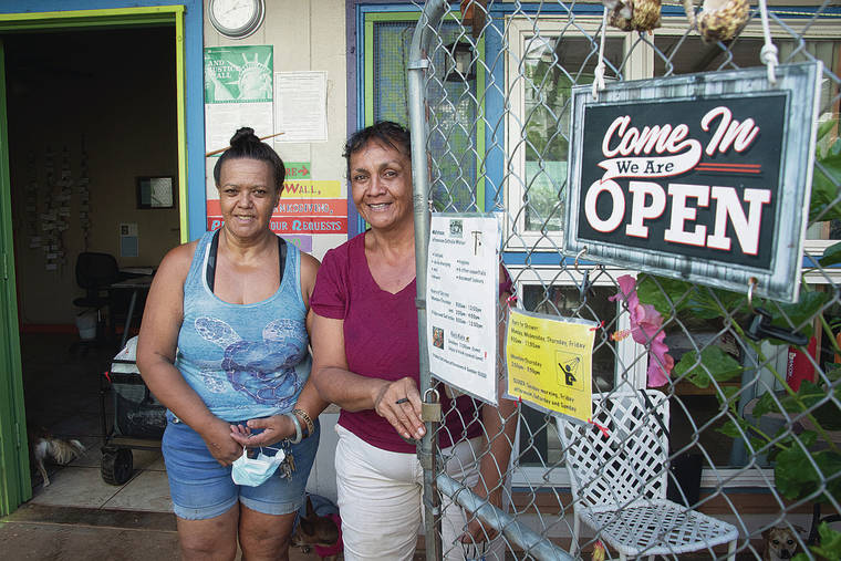 CRAIG T. KOJIMA / CKOJIMA@STARADVERTISER.COM
                                Volunteers Lovely Reiger and Jinna Stevens paused while handing out sandwiches and groceries recently at Wallyhouse at St. Elizabeth’s Episcopal Church in Kalihi. The outreach program provides food to the homeless six days a week.