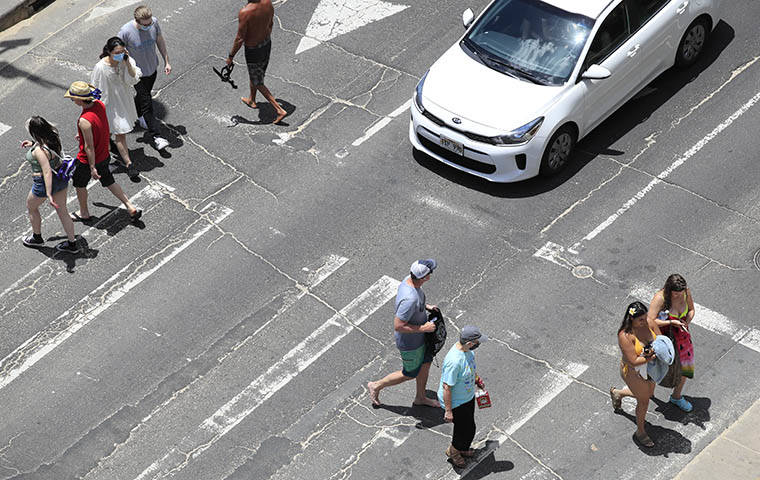 JAMM AQUINO / JAQUINO@STARADVERTISER.COM
                                Pedestrians — some with masks, some without— crossed Kalakaua Avenue, April 26, in Waikiki.