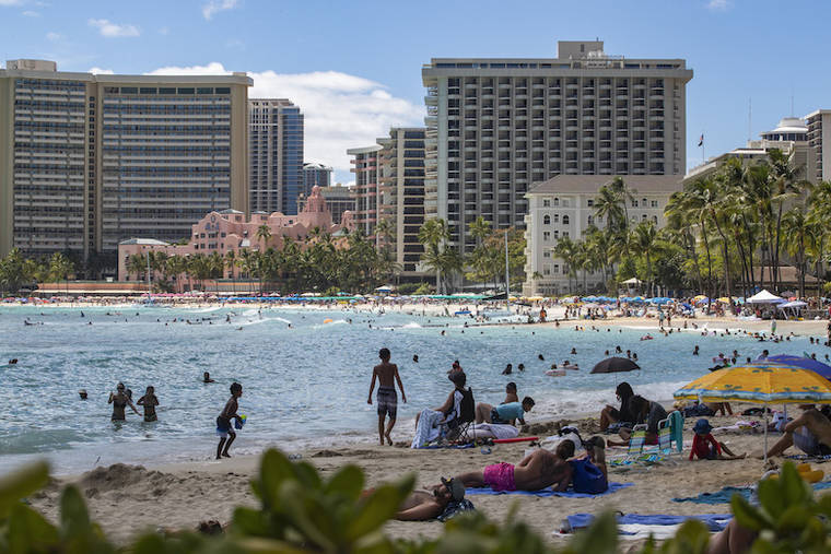 CINDY ELLEN RUSSELL / JULY 8
                                Beachgoers enjoy the sun and surf in Waikiki.
