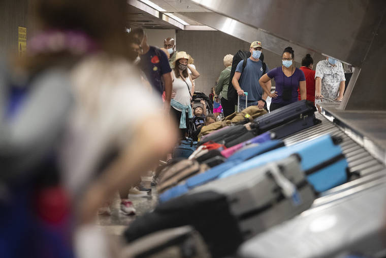 CINDY ELLEN RUSSELL / JULY 19
                                Travelers wait for their luggage at the baggage claim in Terminal 2 at Daniel K. International Airport on Monday.