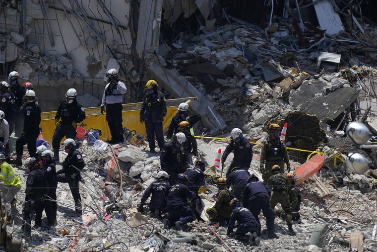ASSOCIATED PRESS
                                Search and rescue personnel work atop the rubble at the Champlain Towers South condo building, where scores of victims remain missing more than a week after it partially collapsed in Surfside, Fla.