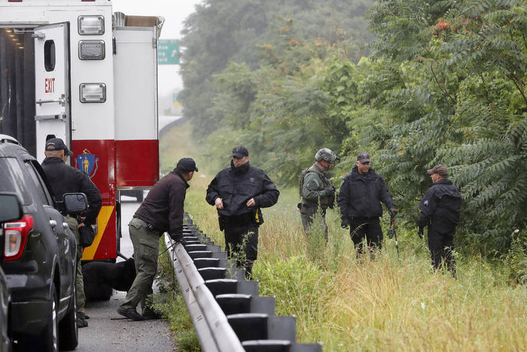 ASSOCIATED PRESS
                                Police work in the area of an hours long standoff with a group of armed men that partially shut down Interstate 95 in Wakefield, Mass.