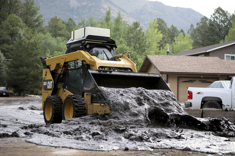 JAKE BACON/ARIZONA DAILY SUN VIA AP
                                A bobcat moves a wet slurry of ash, mud and forest debris into a pile to be removed after the muck was left behind from flooding caused by a monsoon rain event over the 2019 Museum Fire burn area in Flagstaff, Ariz., on Wednesday, July 14. The threat of flash flooding will remain through next week, the National Weather Service said, though the coverage will be more scattered than widespread.