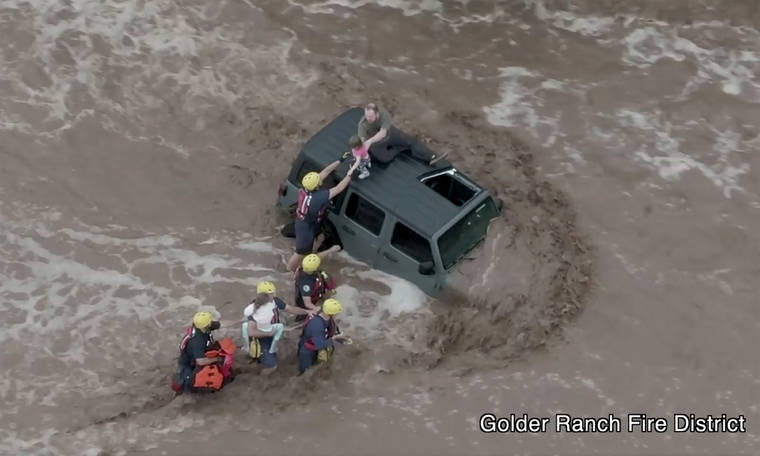 GOLDER RANCH FIRE DISTRICT VIA AP
                                This drone image provided by the Golder Ranch Fire District shows firefighters safely rescue a man and his two daughters from the roof of their vehicle after it was swept away in fast moving water just north of Tucson, Ariz., on Wednesday, July 14.