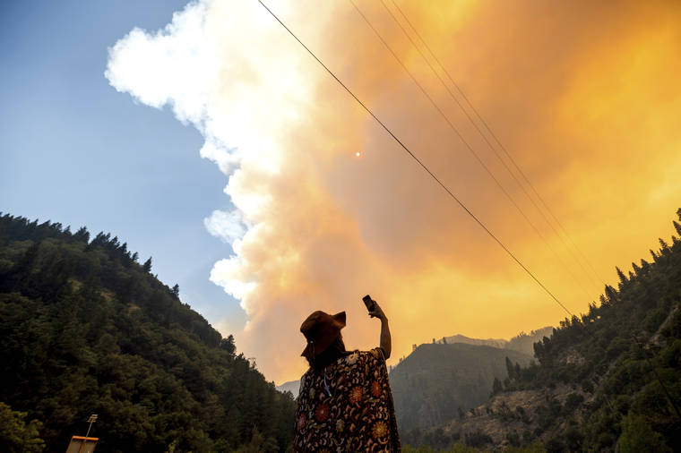 ASSOCIATED PRESS / JULY 16
                                Jessica Bell takes a video as the Dixie Fire burns along Highway 70 in Plumas National Forest, Calif.