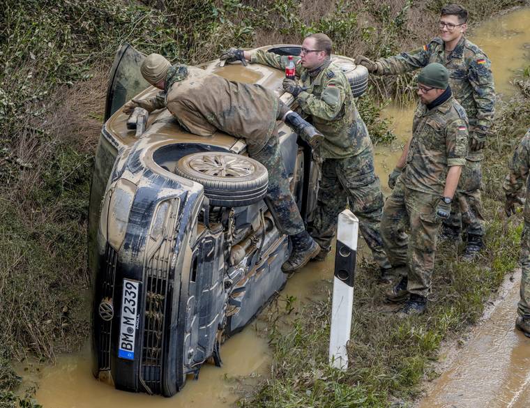 ASSOCIATED PRESS
                                German soldiers work on a flooded car on a road in Erftstadt. Due to strong rainfall, the small Erft river went over its banks causing massive damage.