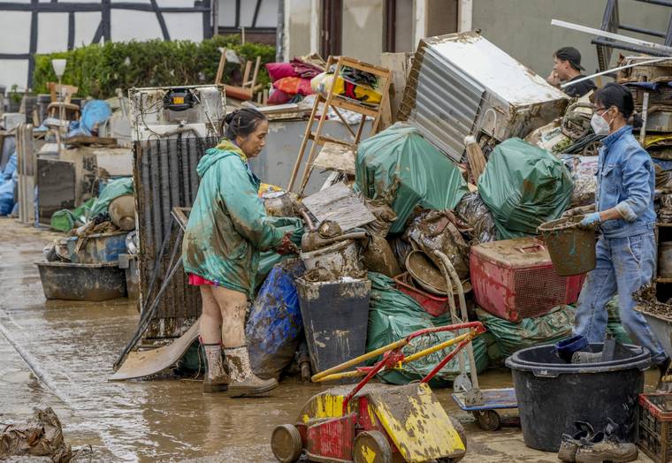 ASSOCIATED PRESS
                                People clean their homes from mud and debris in Bad Neuenahr-Ahrweiler, Germany. Due to strong rainfall, the Ahr river went over its banks and flooded big parts of the town.