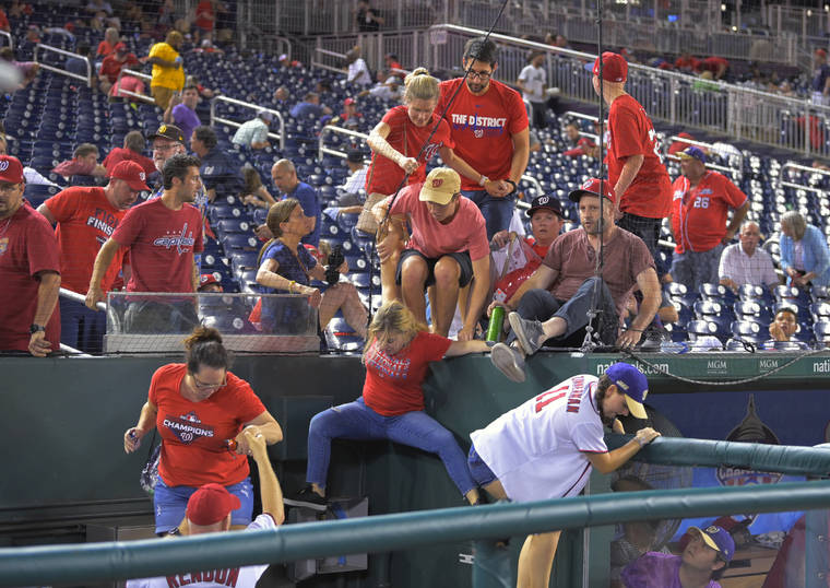 ASSOCIATED PRESS
                                Fans jump into a camera well after hearing gunfire from outside the stadium, during a baseball game between the San Diego Padres and the Washington Nationals at Nationals Park in Washington tonight.
