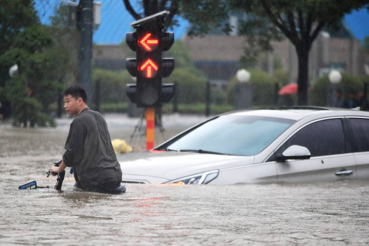 CHINATOPIX VIA ASSOCIATED PRESS
                                A man rode a bicycle through a flooded intersection in Zhengzhou in central China’s Henan Province, Tuesday. China’s military blasted a dam to release floodwaters threatening one of its most heavily populated provinces.