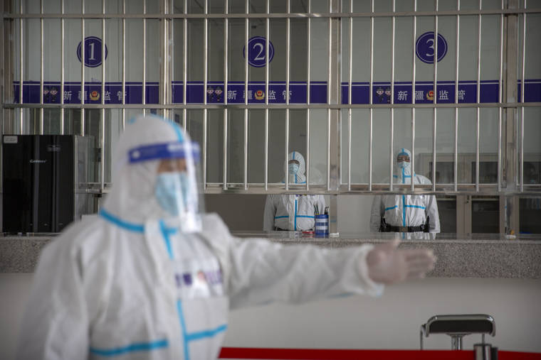ASSOCIATED PRESS
                                A security officer in a protective suit gestures as other officers stand at a reception area at the visitors’ hall at the Urumqi No. 3 Detention Center in Dabancheng in western China’s Xinjiang Uyghur Autonomous Region.