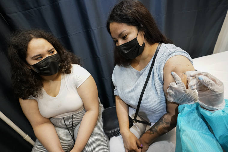 ASSOCIATED PRESS
                                A health care worker inoculates Evelyn Pereira, right, of Brooklyn, with the first dose of the Pfizer COVID-19 vaccine as her daughter Soile Reyes, 12, looks on, Thursday at the American Museum of Natural History in New York. New York City is closing the big vaccination sites to focus on areas with low vaccination rates.