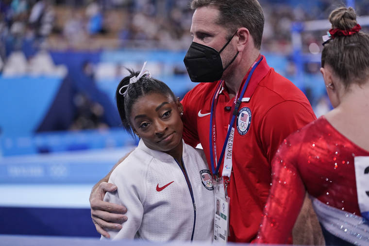 ASSOCIATED PRESS
                                Coach Laurent Landi embraces Simone Biles, after she exited the team final at the Summer Olympics today in Tokyo. The 24-year-old reigning Olympic gymnastics champion Biles huddled with a trainer after landing her vault. She then exited the competition floor with the team doctor.