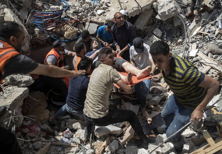 ASSOCIATED PRESS / MAY 16
                                Palestinian rescue a survivor from under the rubble of a destroyed residential building following deadly Israeli airstrikes in Gaza City on May 16. Human Rights Watch today accused the Israeli military of carrying attacks that “apparently amount to war crimes” during an 11-day war against the Hamas militant group in May.