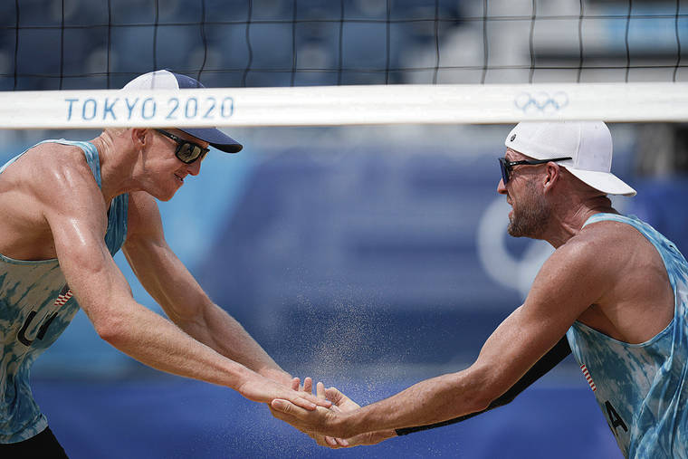 ASSOCIATED PRESS
                                Tri Bourne, left, slapped hands with teammate Jake Gibb during their match today against Switzerland.