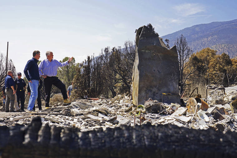 ASSOCIATED PRESS
                                California Gov. Gavin Newsom, front left, and Nevada Gov. Steve Sisolak tour homes destroyed by wildfires near where the Tamarack Fire ignited earlier in July in Gardnerville, Nev., today.