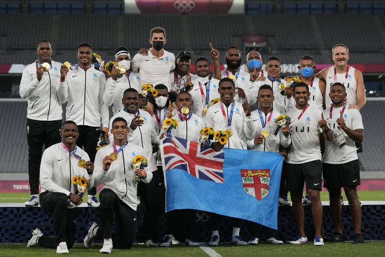 ASSOCIATED PRESS
                                Fiji players and team staff poses with their gold medals and a national flag after winning men’s rugby sevens at the 2020 Summer Olympics on Wednesday.