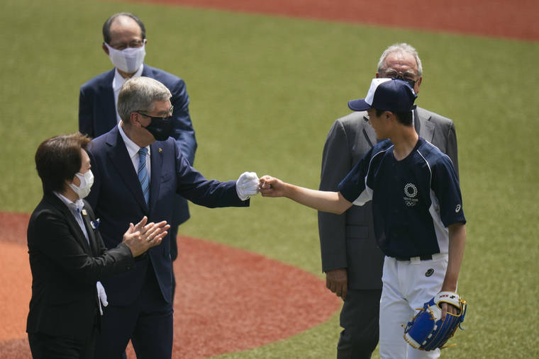 ASSOCIATED PRESS
                                International Olympic Committee President Thomas Bach, left, fist bumps Yuma Takara, 14, after Takara threw the ceremonial first pitch before a baseball game between Japan and the Dominican Republic on Wednesday in Fukushima, Japan.