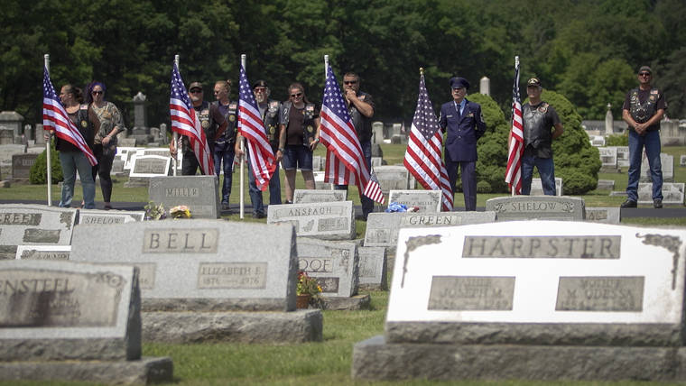 LAUREN SCHNEIDERMAN / PHILADELPHIA INQUIRER VIA AP
                                Veterans hold American flags at the funeral for Cpl. Paul Wilkins at Logan Valley Cemetery on June 16 in Bellwood, Pa.
