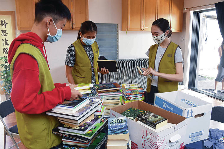 CRAIG T. KOJIMA / CKOJIMA@STARADVERTISER.COM
                                Volunteers Logan Lee, Saty Paynter-­Tavares and Cielle Charron sorted books donated for a mobile library for West Oahu children.