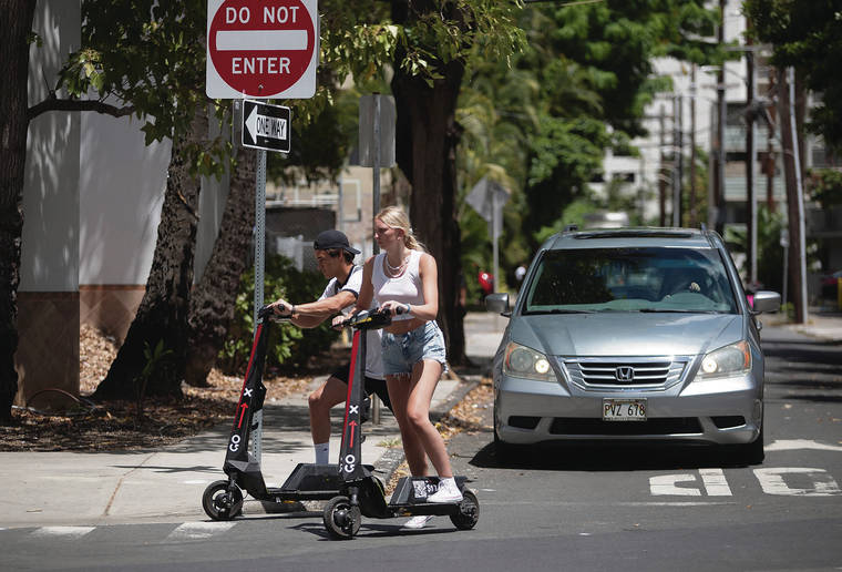 CINDY ELLEN RUSSELL / CRUSSELL@STARADVERTISER.COM
                                A new state law limits electric foot scooter speeds to 15 mph. A pair of Go X scooter riders made a turn onto Lili‘uokalani Avenue in Waikiki on Friday.