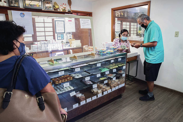 CINDY ELLEN RUSSELL / CRUSSELL@STARADVERTISER.COM
                                Customers purchase goodies from the Nissho­do Candy Store at 1095 Dillingham Blvd. in Kalihi.