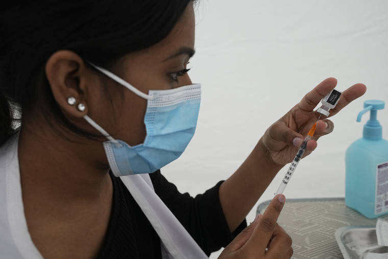 ASSOCIATED PRESS
                                A medical staff prepares a syringe with the Pfizer COVID-19 vaccine at a tent site set up by Doctors Without Borders to vaccinate migrants, the homeless and other marginalized populations in Paris, Thursday.