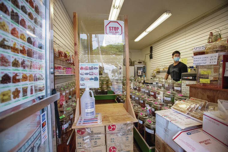 CINDY ELLEN RUSSELL / CRUSSELL@STARADVERTISER.COM
                                 Worker Nick Fang stood ready for customers at The Crack Seed Store in Kaimuki on Monday.