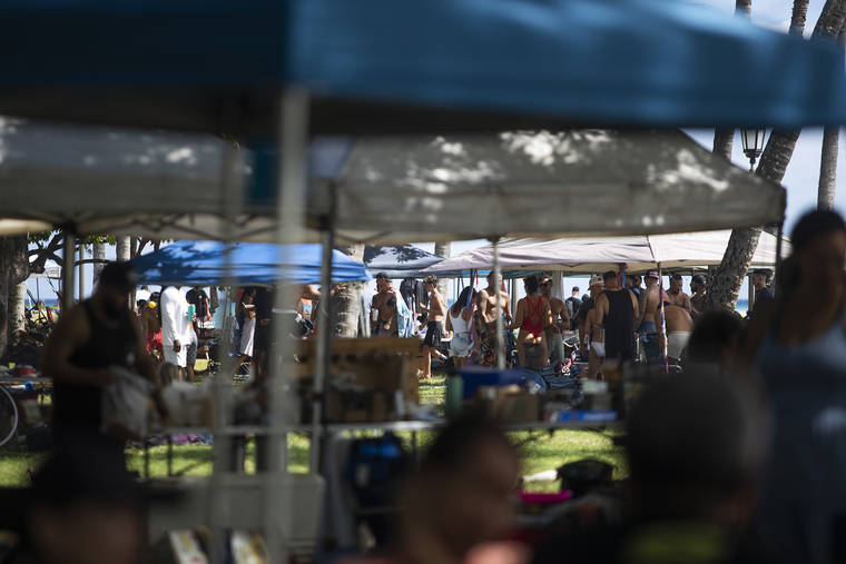 CINDY ELLEN RUSSELL / CRUSSELL@STARADVERTISER.COM
                                People gathered under tents at Queen’s Beach in Waikiki on July 4.