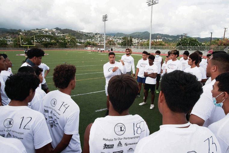 CINDY ELLEN RUSSELL / CRUSSELL@STARADVERTISER.COM 
                                Los Angeles Chargers defensive back Alohi Gilman, center, spoke with youngsters during his first Empower Educate Elevate Football Camp at Farrington High School on Friday.