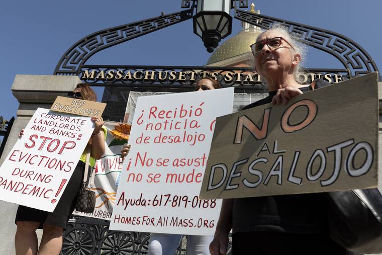 ASSOCIATED PRESS
                                People from a coalition of housing justice groups held signs protesting evictions during a news conference outside the Statehouse, Friday, in Boston.