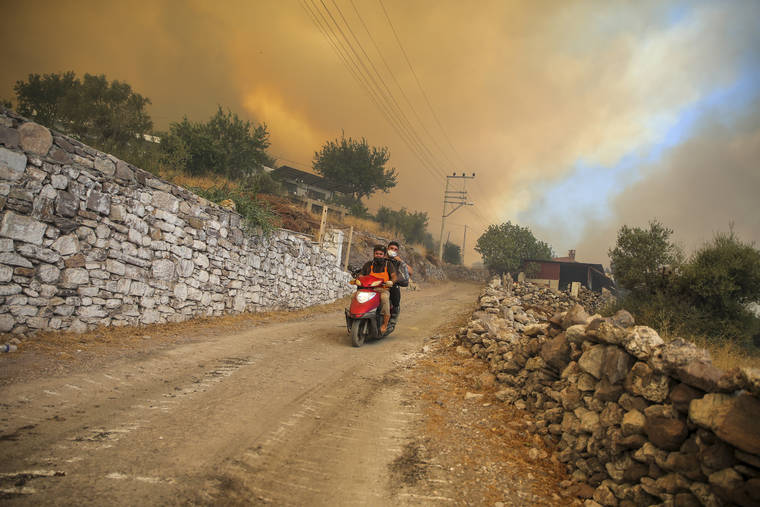 ASSOCIATED PRESS
                                People drive away from an advancing fire in Cokertme village, in Bodrum, Mugla, Turkey, today.