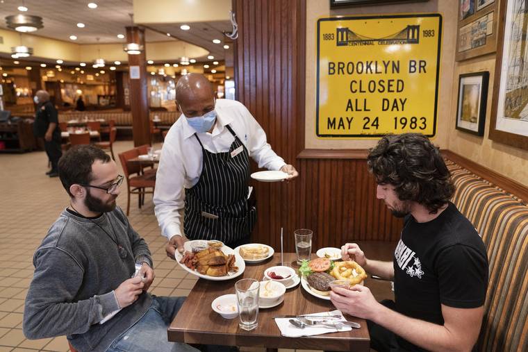 ASSOCIATED PRESS
                                Waiter Lenworth Thompson served lunch, in September 2020, to David Zennario, left, and Alex Ecklin at Junior’s Restaurant in New York. New York City will soon require proof of COVID-19 vaccinations for anyone who wants to dine indoors at a restaurant, see a performance or go to the gym, Mayor Bill de Blasio announced today, making it the first big city in the U.S. to impose such restrictions.