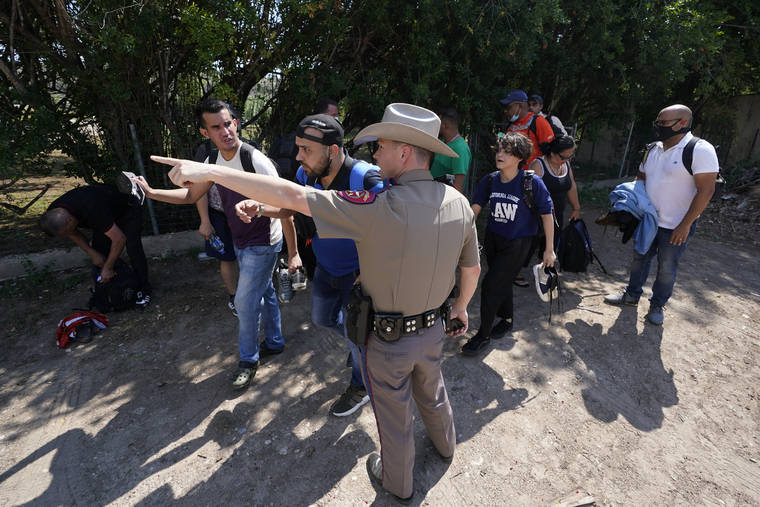 ASSOCIATED PRESS / JUNE 16
                                A Texas Department of Public Safety officer in Del Rio, Texas directs a group of migrants who crossed the border and turned themselves in. The Biden administration sued Texas on Friday, July 30, to prevent state troopers from stopping vehicles carrying migrants on grounds that they may spread COVID-19, warning that the practice would exacerbate problems amid high levels of crossings on the state’s border with Mexico.