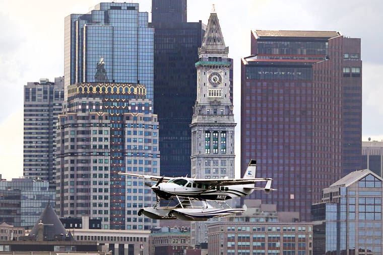 ASSOCIATED PRESS
                                A Tailwind Air commuter seaplane passes the Custom House, center, and the downtown skyline while landing on Boston Harborin Boston. The airline began daily flight service Tuesday to and from New York Harbor.