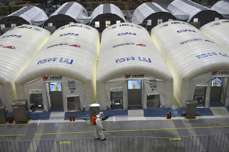 CHINATOPIX VIA ASSOCIATED PRESS
                                A worker disinfected the flooring outside the inflated cabins at the pop-up Huo-Yan Laboratory set up in an expo center to test samples for COVID-19 virus in Nanjing in east China’s Jiangsu province, Wednesday.