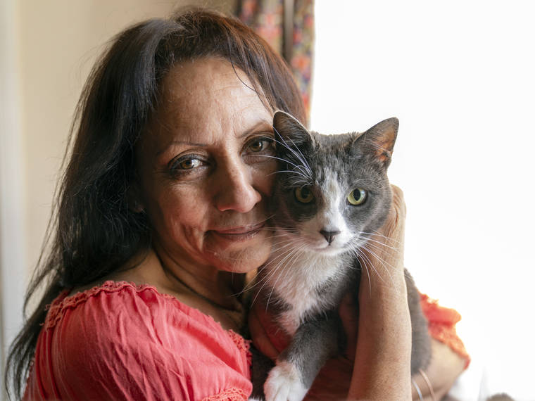 ASSOCIATED PRESS
                                Veronica Perez hugged her cat, Brooklyn, at her new home, June 30, at a Homekey site in Los Angeles. She took residence in one of 6,000 new units built statewide over the last year as part of Project Homekey.