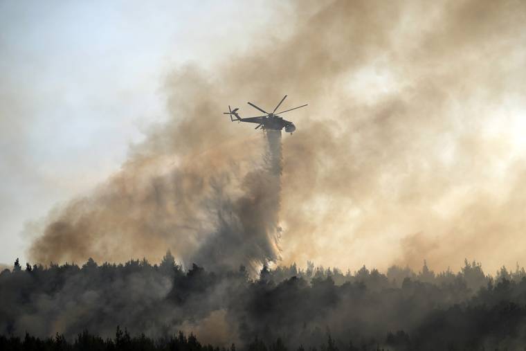 ASSOCIATED PRESS
                                An helicopter drops water over a fire in Varibobi area, northern Athens, Greece. Firefighting planes were resuming operation at first light Wednesday to tackle a major forest fire on the northern outskirts of Athens which raced into residential areas the previous day, forcing thousands to flee their homes amid Greece’s worst heatwave in decades.