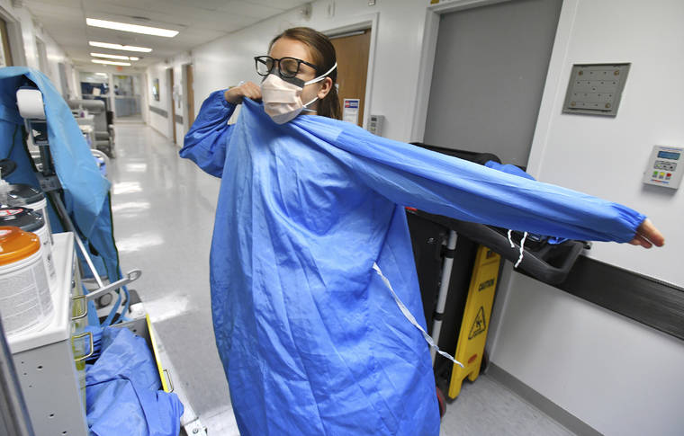 BOB SELF/THE FLORIDA TIMES-UNION VIA ASSOCIATED PRESS
                                RN Zoe Zinis put on fresh protective layers before entering the room of an infected patient in the COVID-19 ward at UF Health’s downtown in Jacksonville, Fla., campus, July 30. The second surge of COVID-19 infections in Jacksonville is stretching the capacity of area medical facilities to care for patients.