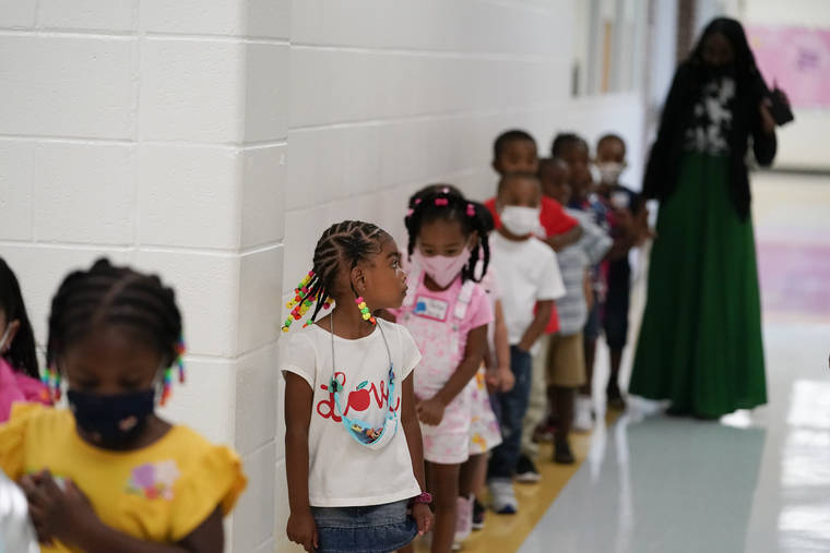 ASSOCIATED PRESS
                                Students walked down the hallway at Tussahaw Elementary school, Wednesday, in McDonough, Ga. Schools have begun reopening in the U.S. with most states leaving it up to local schools to decide whether to require masks.