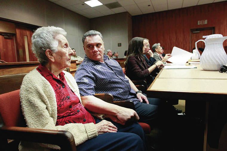 STAR-ADVERTISER / 2015
                                Gerard Puana, center, is continuing a civil case he has against the city, Katherine Kealoha and six former police officers. He also added the estate of Florence Puana, left, as a plaintiff. She died in February 2020. The Puanas listen to the verdict in a civil suit against Kealoha over money derived from a reverse mortgage on Florence Puana’s home.