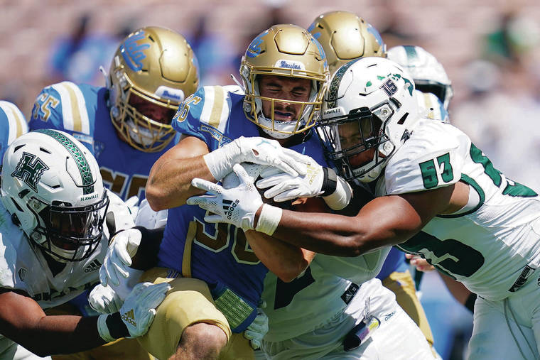 ASSOCIATED PRESS
                                Hawaii linebacker Darius Muasau tackled UCLA running back Ethan Fernea on Saturday. Muasau and the rest of the Warriors paid tribute to former quarterback Colt Brennan by wearing No. 15 on their helmet.
