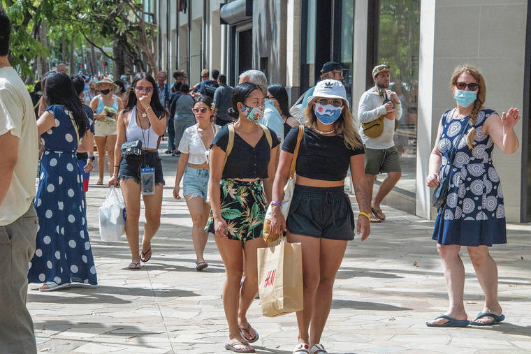 CRAIG T. KOJIMA / CKOJIMA@STARADVERTISER.COM
                                Masked and unmasked people Saturday walked the sidewalks of Kalakaua Avenue in Waikiki.