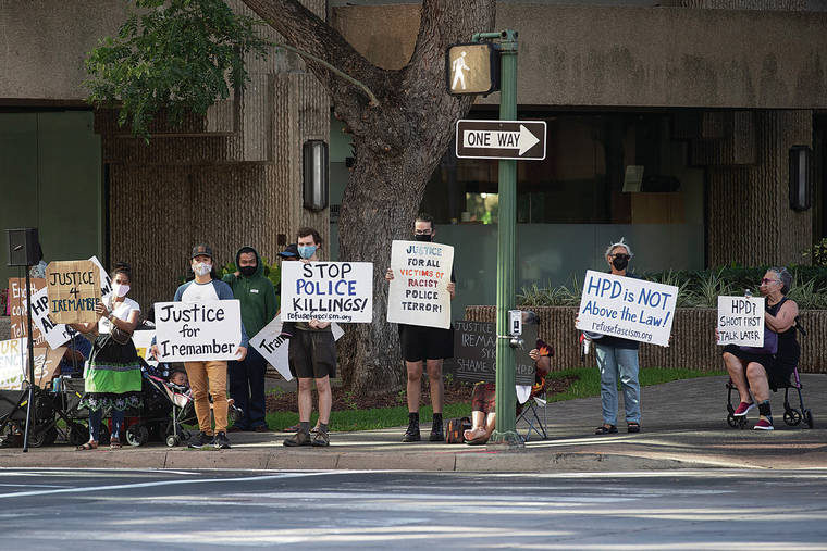 GEORGE F. LEE / GLEE@STARADVERTISER.COM
                                Protesters held signs for Iremamber Sykap Wednesday at the corner of Hotel and Alakea streets during the hearing for Honolulu Police officers Geoffrey Thom, Zackary Ah Nee and Christopher Fredeluces.