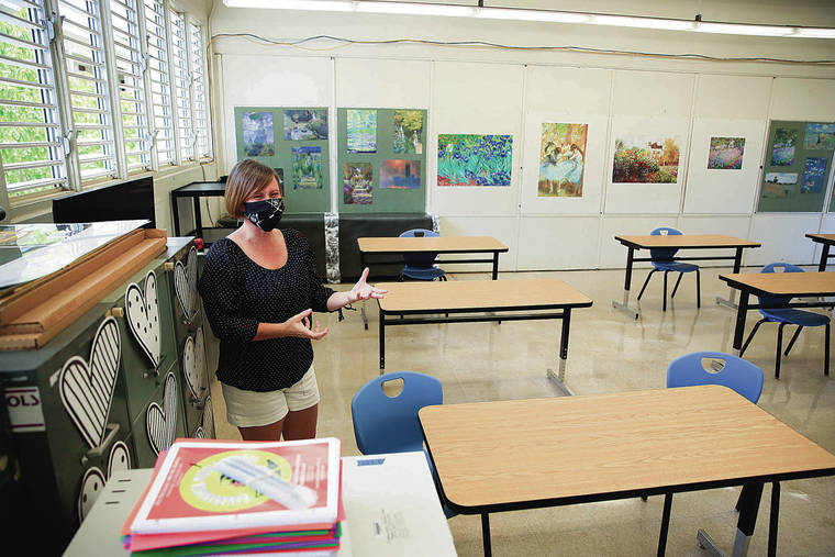 JAMM AQUINO / JAQUINO@STARADVERTISER.COM
                                Hawaii public school resumes in-person classes today amid a surge in positive COVID-19 cases. Above, sixth grade English teacher Corrie Izumoto on Monday showed the distance between desks in her classroom at Kawananakoa Middle School.