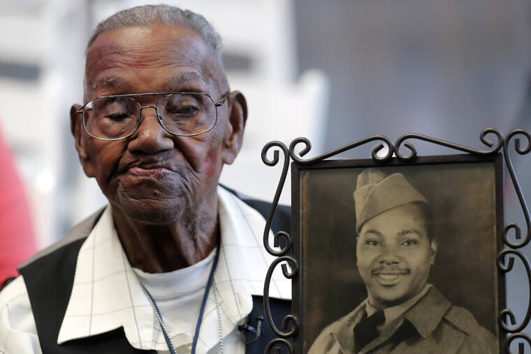 ASSOCIATED PRESS
                                World War II veteran Lawrence Brooks held a photo of himself taken in 1943, as he celebrated his 110th birthday, in September 2019, at the National World War II Museum in New Orleans. Brooks celebrated his 112th birthday, Sunday, with a drive-by party at his New Orleans home hosted by the National War War II Museum.