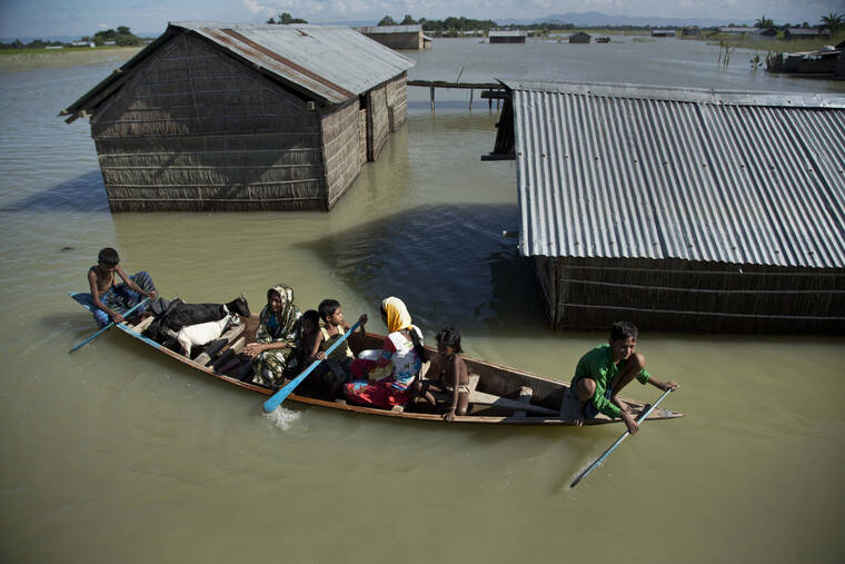 ASSOCIATED PRESS / JULY 31, 2016
                                A flood-affected family with their goats travel on a boat in the Morigaon district, east of Gauhati, northeastern Assam state, India, in 2016. Climate change could push more than 200 million people to move within their own countries in the next three decades and create migration hotspots unless urgent action is taken in the coming years to reduce global emissions and bridge the development gap, a World Bank report has found.