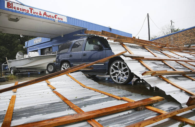 ELIZABETH CONLEY/HOUSTON CHRONICLE VIA ASSOCIATED PRESS
                                Parts of a roof sat on top of a car parked at Blessings Tire and Auto Care following Hurricane Nicholas in Bay City, Texas, Tuesday. According to the owner of the business, he wasn’t sure where the roof came from.